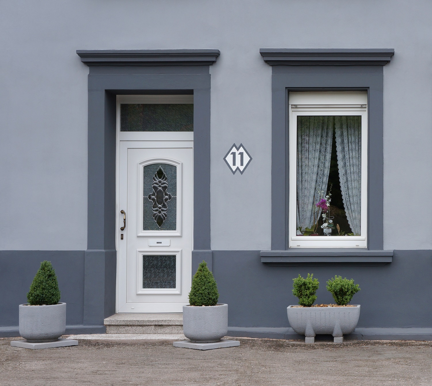 exterior Wooden doors London in white installed in the house with blue facade.